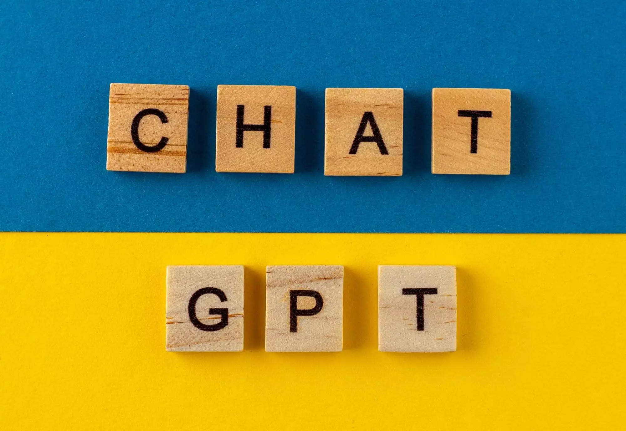 ChatGPT background. Words in wooden letters. Chat with AI or Artificial Intelligence by OpenAI.